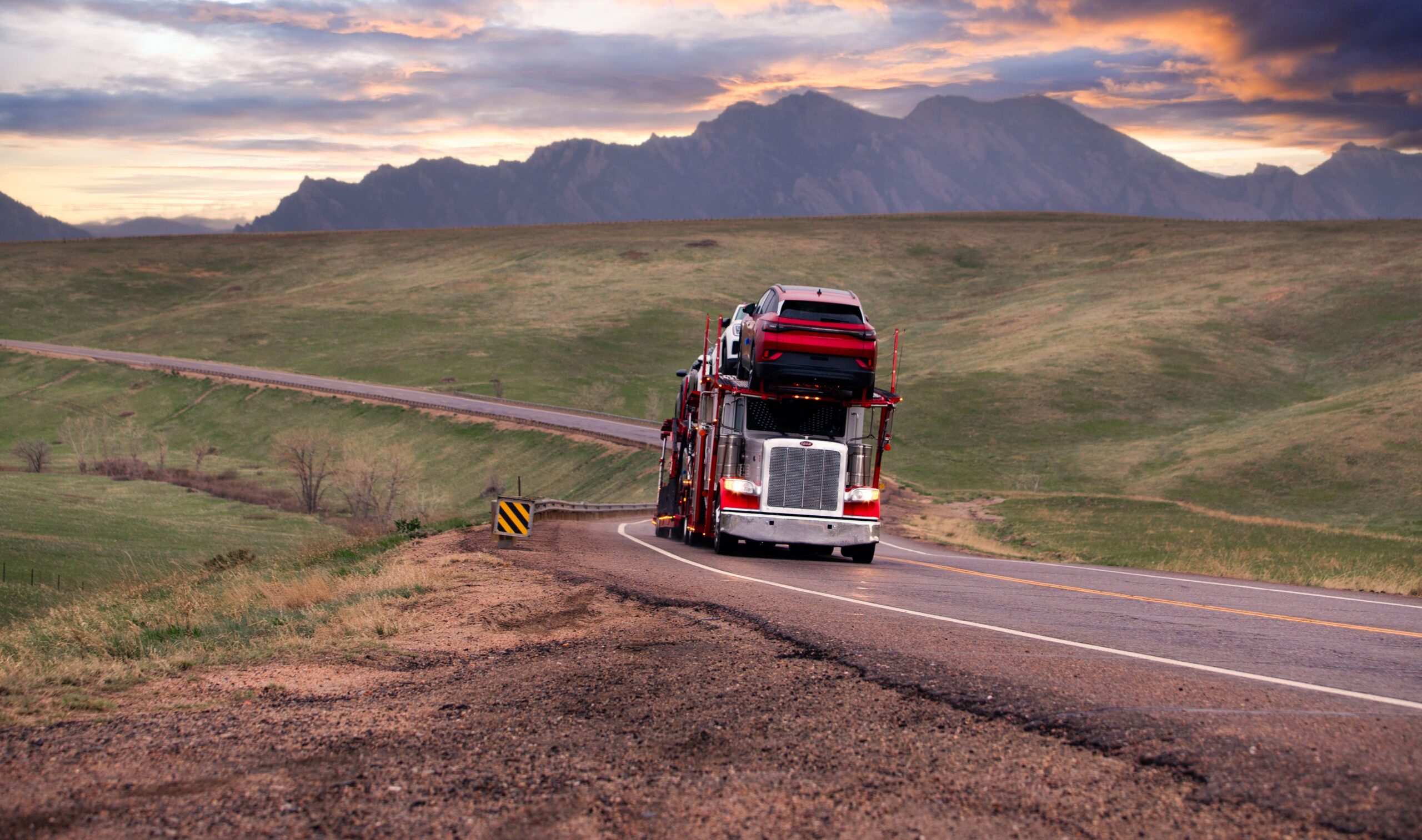 Accelerated car hauler loaded with new vehicles for dealer delivery