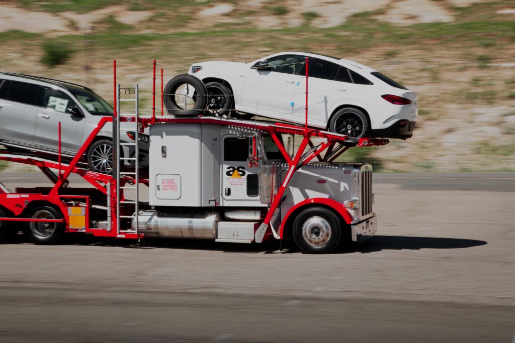 Accelerated car hauler with SUVs on the truck package, moving down a highway